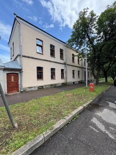 a large white building with windows on a street at Ravelin in Narva