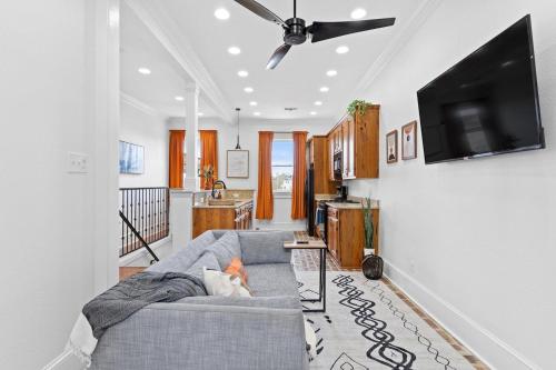 a living room with a couch and a flat screen tv at Mid-City 2BR w Balcony Near Canal Streetcar in New Orleans