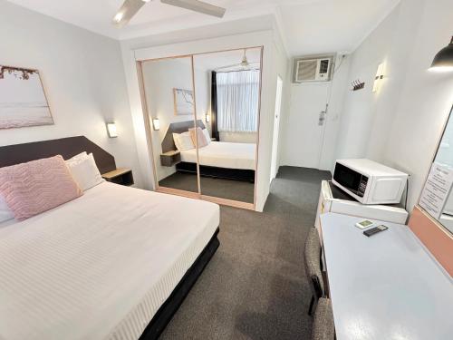 a hotel room with a bed and a tv at Golden Sands Motor Inn in Forster