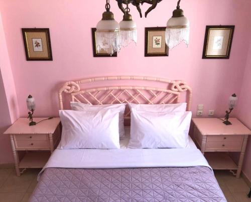 a pink bedroom with a bed and two night stands at Villa Zante Estrella in Kalamaki