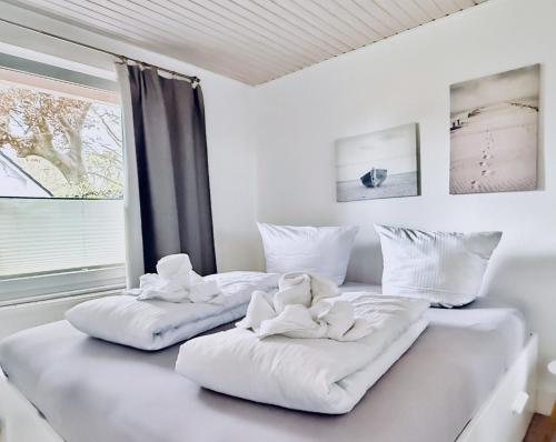 een wit bed met twee teddyberen erop bij Sonnensteg 5 - Ein Tag am Meer in Ostseebad Sellin