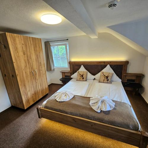 a bedroom with a large bed with two pillows at Schwaben Resort Ebnisee in Ebni