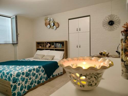 a bedroom with a bed and a large vase at La Rosa di Antonio -Relax Room in Tricase