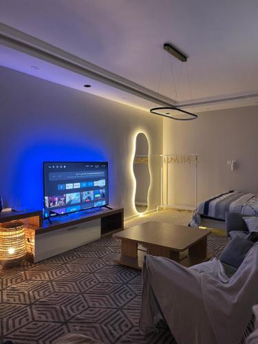 Una sala de estar con un sofá y un televisor. en Safety house, en Tabuk