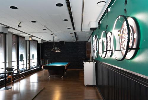 una mesa de billar en una habitación con una pared verde en Grand Salo Hotel, en Salo