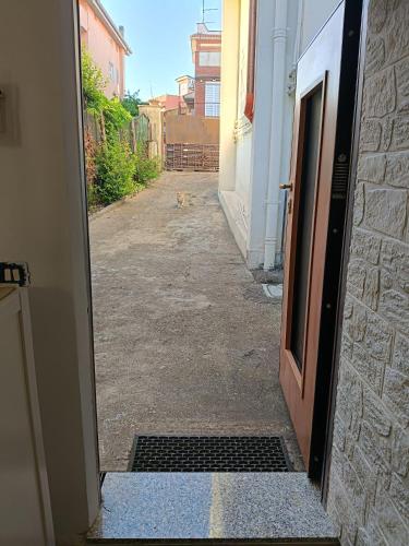 an open door to an alley with a cat sitting outside at Casina Appia Antica in Marino