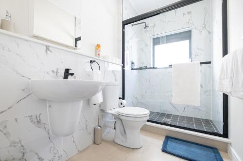 a white bathroom with a sink and a toilet at #AlimamaSpaces Manson's Fynbos Villa in Cape Town