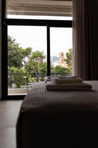 a bedroom with a bed and a large window at Aesthe Suites Noir in Xanthi