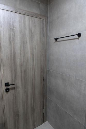 a shower with a wooden door in a bathroom at Aesthe Suites Noir in Xanthi