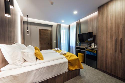 a bedroom with a large bed and a television at Salt Lake Hotel in Sovata