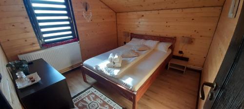 a small room with a bed in a cabin at La Ianis in Vatra Dornei