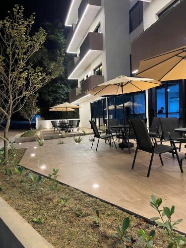 a patio with tables and umbrellas in front of a building at Hotel Quinta do Lago in Cunha