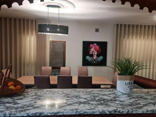 a dining room with a table with chairs and a painting at Abadia House - Geres in Geres