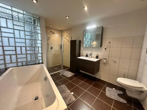 a bathroom with a tub and a toilet and a sink at Wunderschönes Loft in Bayreuth - 170qm in Bayreuth