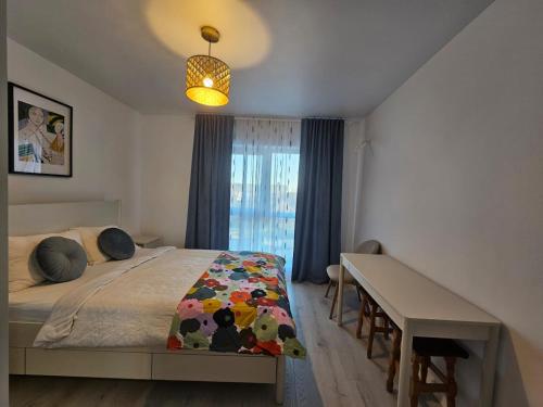 a bedroom with a bed and a desk and a window at Apartament nou si modern lanaga metrou in Bucharest