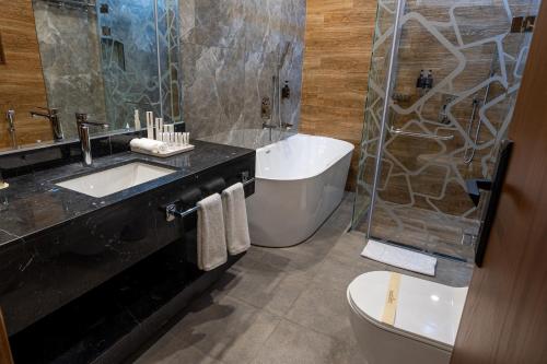 a bathroom with a sink and a shower and a toilet at فندق الترحيب Atarheeb Hotel in Tabuk