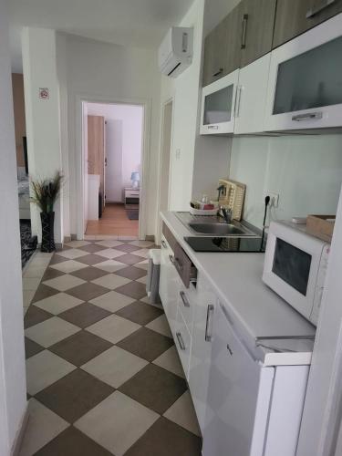 a kitchen with a checkered floor and white appliances at Apartman D&D in Jajce
