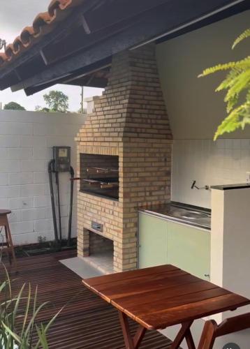 a patio with a wooden table and a brick oven at Apto mobiliado para 4 pessoas Belém COP 30 in Belém