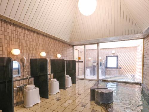 a bathroom with three toilets and a pool of water at APA Hotel Ogaki Ekimae in Ogaki