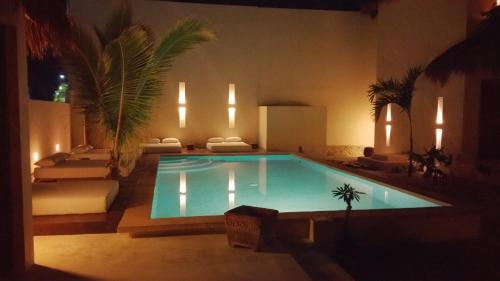 a room with a pool, chairs, and a pool table at Tierra del Mar Hotel - Adults Only in Holbox Island