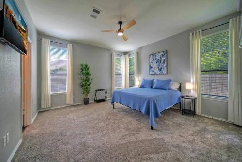 a bedroom with a blue bed and a ceiling fan at Sunny Delight Of Pville - Where Days Are Bright in Pflugerville
