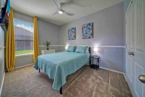 a bedroom with a bed with a blue bedspread at Sunny Delight Of Pville - Where Days Are Bright in Pflugerville