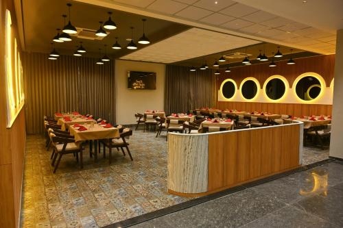 a dining room with tables and chairs in a restaurant at Hotel Mivaante in Ahmedabad