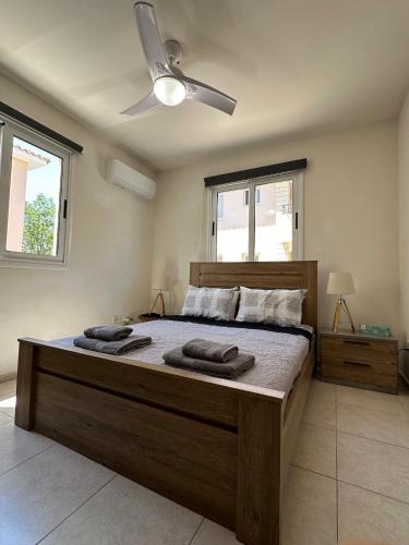 a bedroom with a large bed with two towels on it at Majestic Gardens 10 minutes from Larnaka Airport in Tersephanou