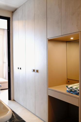 a bathroom with white cabinets and a sink at Casa Narrow Villa in Nembrala