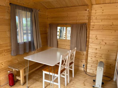 a dining room in a log cabin with a table and chairs at Búdardalur glamping in Búðardalur