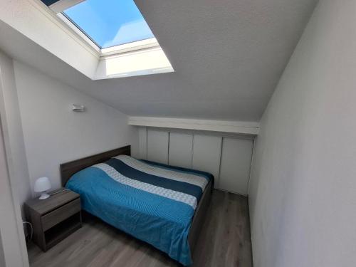 une chambre avec un lit et une lucarne dans l'établissement Appart Must1 Minimes avec Piscine, à La Rochelle