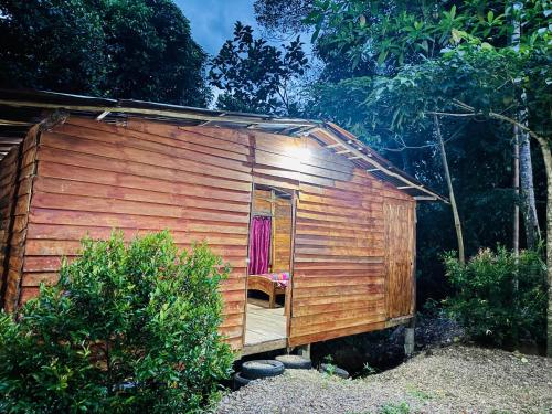 a wooden shed with a chair in the doorway at Won Happy Hotel - Kitulgala in Kitulgala