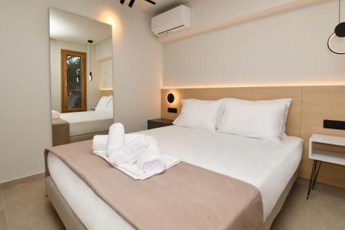 a bedroom with a large white bed and a bathroom at Thrive in Sarti