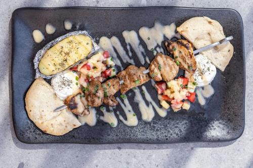 a tray of food with meat and vegetables on it at Pearl SeaBreeze Suites in Rethymno Town