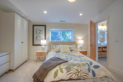 a bedroom with a bed and two lamps and a window at Bright, Contemporary, Walk To Town & Beach in Eastsound