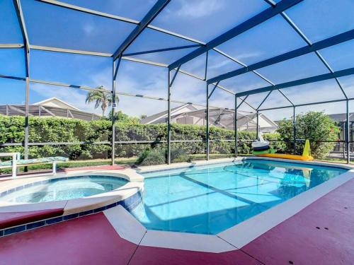 a large swimming pool with a large roof at Family villa w pool, spa & arcade in Orlando