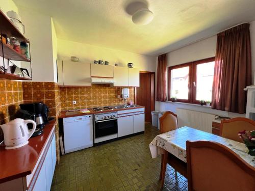 a kitchen with white appliances and a table with a tableablish at Exclusives Ferienhaus in Frankenau im Sauerland in Frankenau