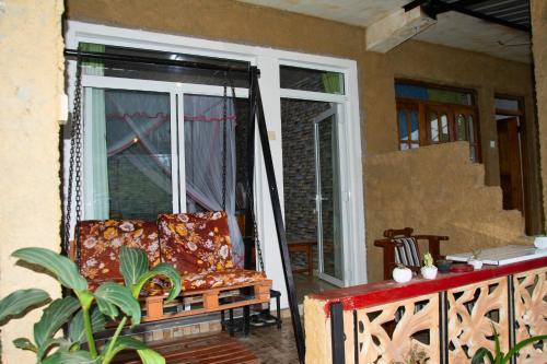 a porch with a swing and a chair on a balcony at Secret View Homestay Ella in Ella