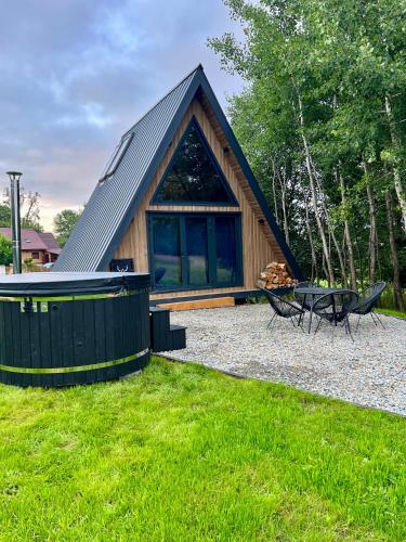 a cabin with a pitched roof and a picnic table at Jelenie Brdy in Brzegi Dolne