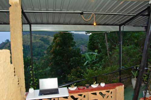 a laptop sitting on a table with a view of a mountain at Secret View Homestay Ella in Ella
