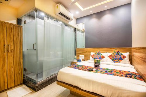 a bedroom with a bed and a glass shower at FabExpress Marol Metro in Mumbai
