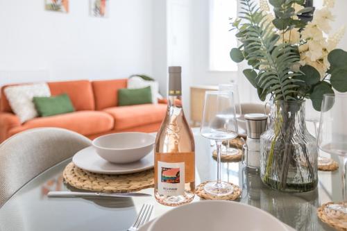 a glass table with a bottle of wine and a bowl at Stylish 4 Bed House In Chorley in Chorley