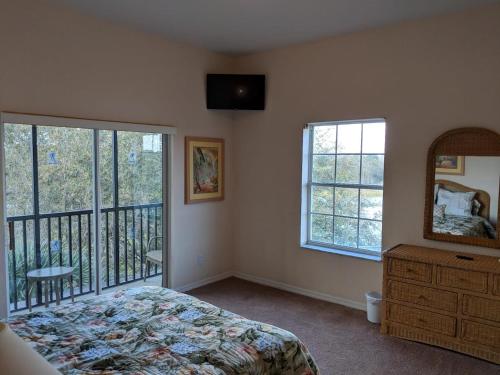 Un dormitorio con una cama y un espejo y un balcón. en Bahama Bay Resort - Grand Bahama Penthouse, en Kissimmee