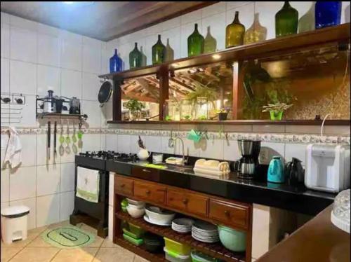 - une cuisine avec un comptoir avec des bouteilles murales dans l'établissement Casaaconchego, à Parati