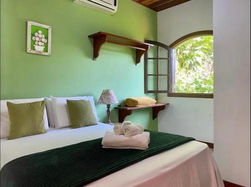 une chambre avec un lit avec des serviettes dessus dans l'établissement Casaaconchego, à Parati