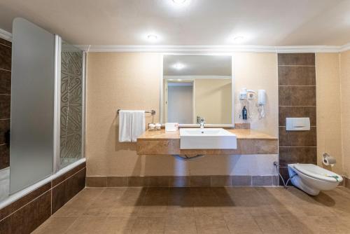 a bathroom with a sink and a toilet at Kaya Belek in Belek