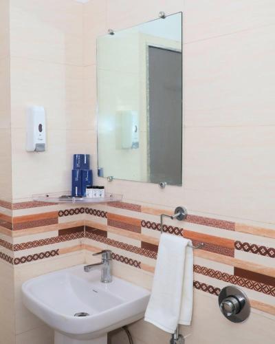 a bathroom with a sink and a mirror at Hotel Shri Radha Nikunj - Opposite Prem Mandir in Vrindāvan