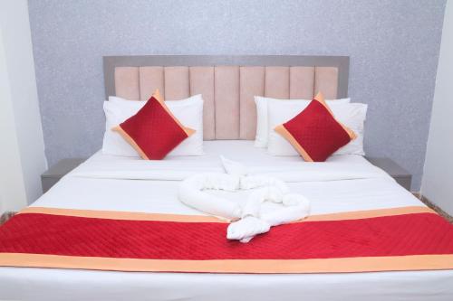 a bed with a white towel laying on it at Hotel Shri Radha Nikunj - Opposite Prem Mandir in Vrindāvan