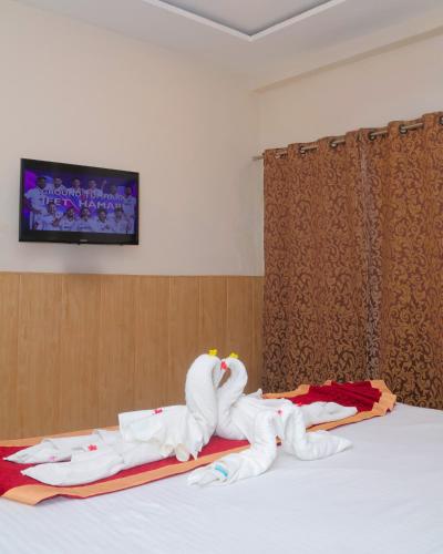 a bedroom with a bed with towel animals on it at Hotel Shri Radha Nikunj - Opposite Prem Mandir in Vrindāvan