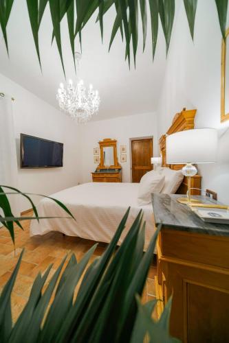 a bedroom with a large bed and a chandelier at Domus Emma in Cantalupo in Sabina